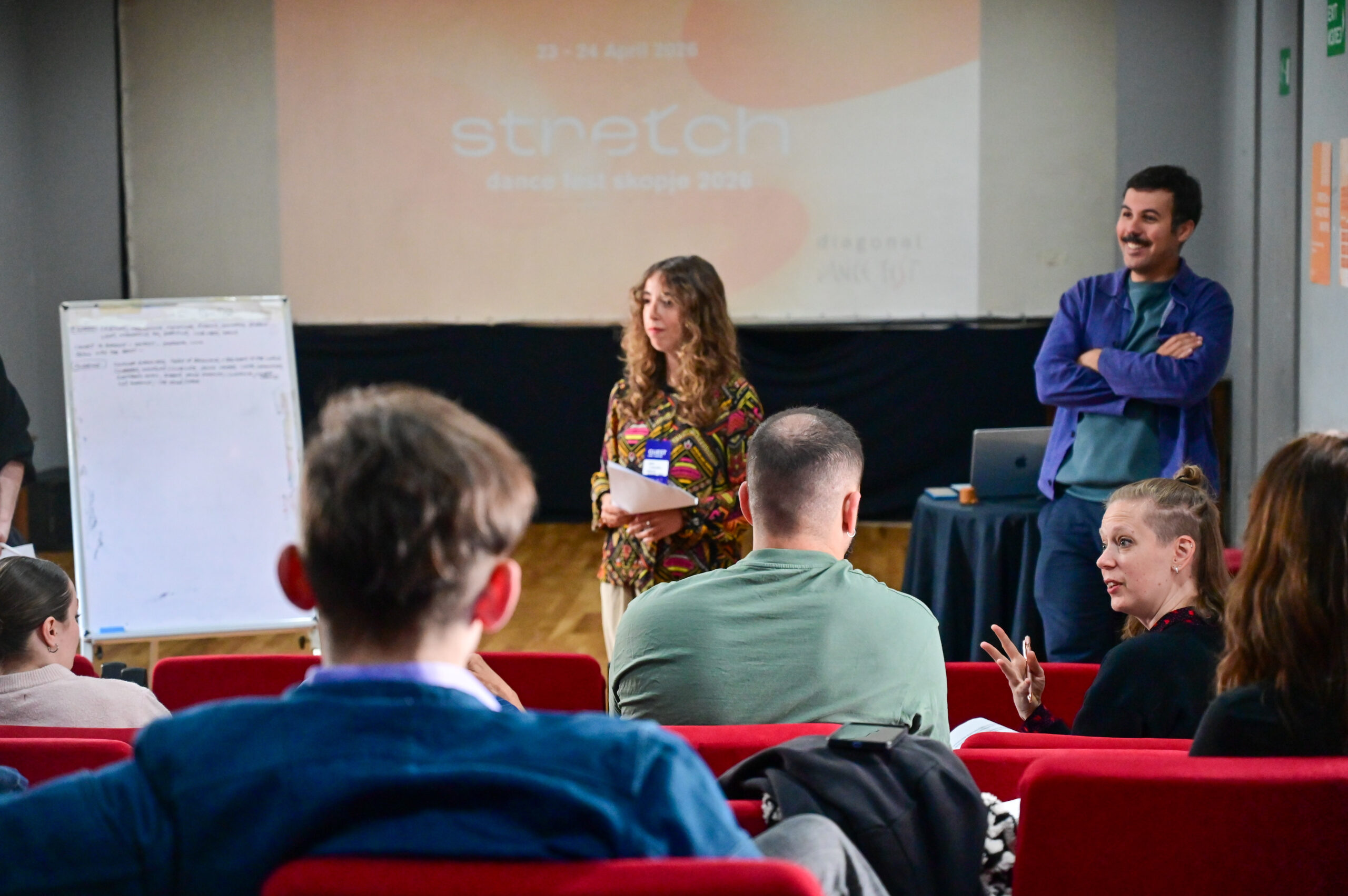 Two facilitators leading a workshop to a group of dance professionals.